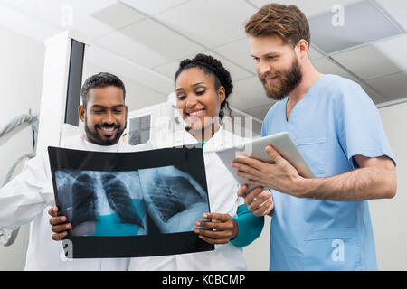 I radiologi con i raggi X al torace e tavoletta digitale in ospedale Foto Stock