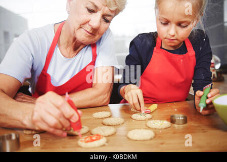 Nonna con ragazza decorazione di biscotti di Natale Foto Stock