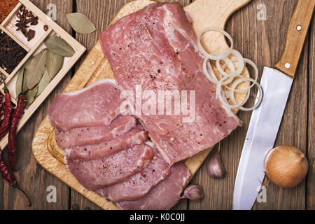 Carbonato di maiale su un tagliere con ingredienti, vista dall'alto Foto Stock