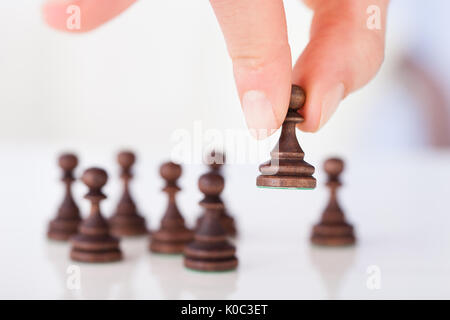 Immagine ritagliata della donna di mano azienda scacchi pedina sulla tavola Foto Stock