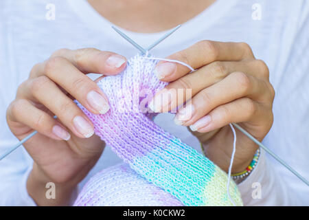 Maglia sciarpa aghi mani multicolori Foto Stock