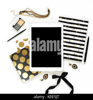 Appartamento laico femminile di moda home office area di lavoro con la tavoletta, nero elegante notebook d'oro, di cosmetici e di gioielli su sfondo bianco. vista dall'alto sulla donna lavoro di business desk Foto Stock