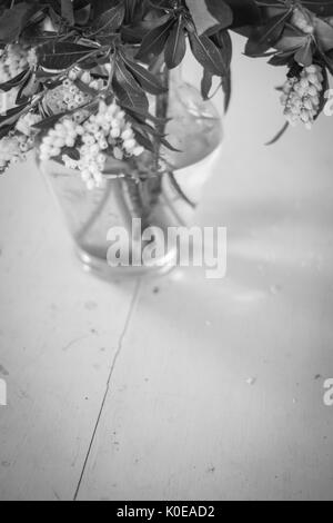 In bianco e nero con motivi floreali sul display di un dipinto di un tavolo di legno. Foto Stock