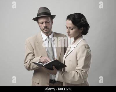 Vintage manager e segretario lavorando insieme controllare le note e gli appuntamenti Foto Stock