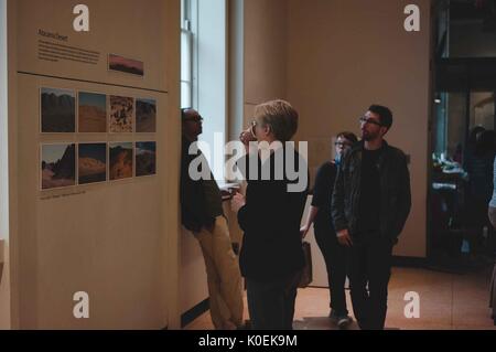 Gli studenti universitari e i membri della Johns Hopkins e mica europee esaminare gli oggetti sul display per l'apertura di ritorno sulla terra: la preparazione di un viaggio verso Marte, una mostra e una collaborazione tra il Maryland institute College of Art (mica) e Johns Hopkins University, che ha avuto luogo presso la galleria q in milton s. eisenhower libreria su homewood campus della Johns Hopkins University di Baltimora, Maryland. 2014. cortesia eric chen. Foto Stock