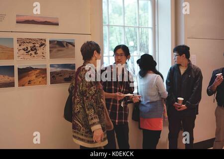 Gli studenti universitari e i membri della Johns Hopkins e mica europee socializzare e di esaminare gli oggetti sul display per l'apertura di ritorno sulla terra: la preparazione di un viaggio verso Marte, una mostra e una collaborazione tra il Maryland institute College of Art (mica) e Johns Hopkins University, che ha avuto luogo presso la galleria q in milton s. eisenhower libreria su homewood campus della Johns Hopkins University di Baltimora, Maryland. maggio, 2014. cortesia eric chen. Foto Stock