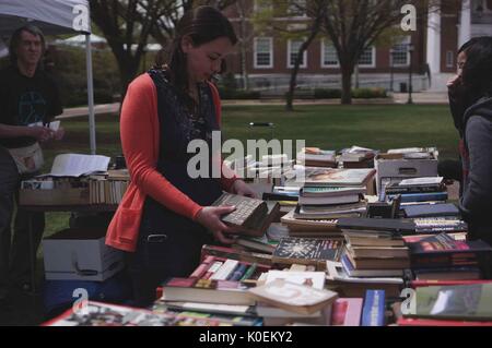 Gli studenti universitari e i membri delle comunità Johns Hopkins e Baltimora esamineranno i libri che sono stati allestiti da un fornitore per la fiera di primavera, un festival annuale con musica, cibo, shopping, E molto altro ancora che si svolge ogni primavera nel campus Homewood della Johns Hopkins University di Baltimora, Maryland, aprile 2014. Cortesia Eric Chen. Foto Stock