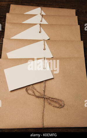 Nota da una carta su una corda di una busta da carta kraft su un tavolo di legno Foto Stock