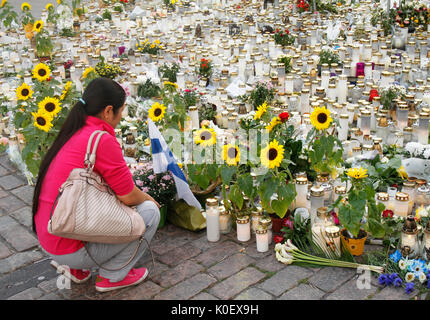 Turku, Finlandia. 22 Ago, 2017. Una donna che è di non-etnica origine finlandese pagando il rispetto per le vittime alla scena di Turku attacco di coltello in cui uno dei due omicidi ha avuto luogo il 18 agosto 2017. Quattro giorni dopo terrosristic rampage persone sono ancora portando fiori e candele memoriale per le vittime a Turku Piazza del Mercato Centrale. Credito: Jukka Palm/Alamy Live news. Foto Stock