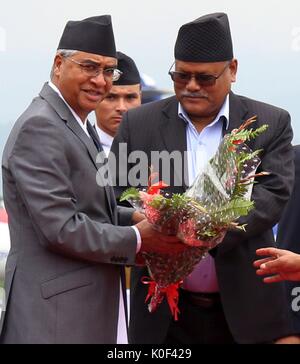 (170823) -- Kathmandu, e il agosto 23, 2017 (Xinhua) -- il nepalese il Primo ministro Sher Bahadur Deuba (L) riceve i fiori prima di partire per l'India al l'aeroporto internazionale di Tribhuvan di Kathmandu, capitale del Nepal, e il agosto 23, 2017. Il nepalese il Primo ministro Sher Bahadur Deuba ha intrapreso una cinque giorni di visita di Stato in India il mercoledì. (Xinhua/Sunil Sharma) (SWT) Foto Stock