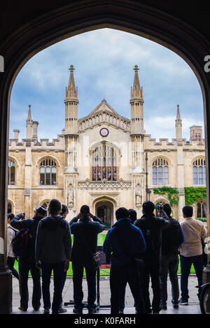 I turisti di Cambridge, un gruppo di turisti, si trovano sotto l'entrata ad arco del Corpus Christi College per guardare il New Court Building, Regno Unito. Foto Stock