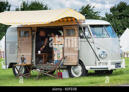 L'uomo facendo una tazza di tè in un 1958 VW split screen camper a un vintage retrò festival. Regno Unito Foto Stock