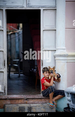 Cubano, Cuba, Cardenas, piccolo ragazzo e il suo cane vicino a Park Plaza de Spriu Foto Stock