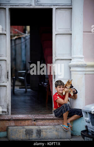 Cubano, Cuba, Cardenas, piccolo ragazzo e il suo cane vicino a Park Plaza de Spriu Foto Stock