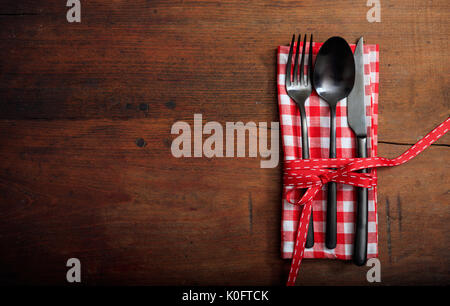 Impostazione tabella con una forchetta, cucchiaio e coltello sullo sfondo di legno Foto Stock