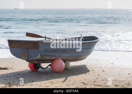 La pesca dinghy seduto su boe sul litorale Foto Stock