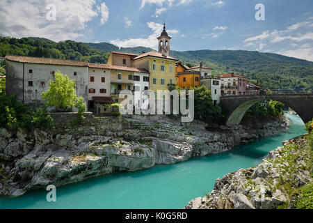 Stucco di colorate case sul turchese Soca River con ponte in pietra a sezione antica di Kanal Slovenia con assunzione di Maria la Chiesa Foto Stock