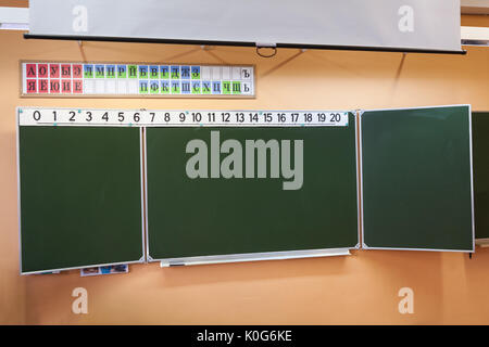 Verde lavagna pulita in aula della scuola in Russia. Numeri e alfabeto russo è sulla parte superiore Foto Stock