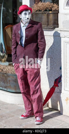 Venezia,l'Italia,26 Febbraio 2011: un uomo mascherato in un rosso Charlie Chaplin costume comporta per i turisti il sestiere di Castello a Venezia durante la Venezia Foto Stock