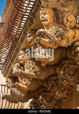 Riccamente intagliato balcone in pietra supporta il barocco Palazzo Villadorata a Noto, a sud della Sicilia Orientale Foto Stock