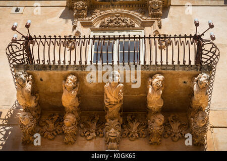 Riccamente intagliato balcone in pietra sul barocco Palazzo Villadorata a Noto, a sud della Sicilia Orientale Foto Stock