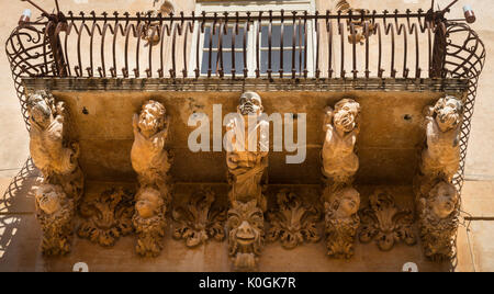 Riccamente intagliato balcone in pietra sul barocco Palazzo Villadorata a Noto, a sud della Sicilia Orientale Foto Stock