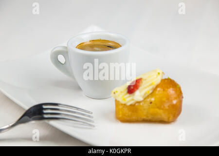 Babà napoletano e caffè sul bianco piatto bianco Foto Stock