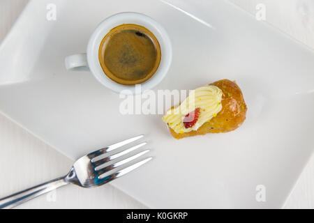 Babà napoletano e caffè sul bianco piatto bianco Foto Stock