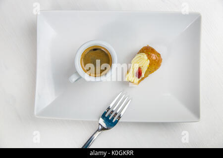 Babà napoletano e caffè sul bianco piatto bianco Foto Stock