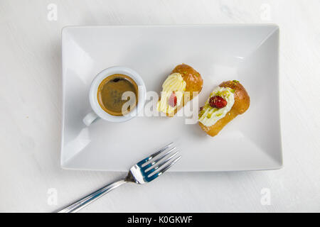 Babà napoletano e caffè sul bianco piatto bianco Foto Stock