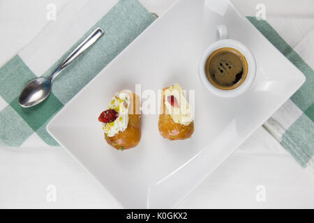 Babà napoletano e caffè sul bianco piatto bianco Foto Stock