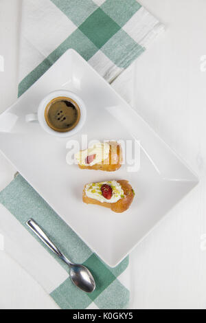 Babà napoletano e caffè sul bianco piatto bianco Foto Stock