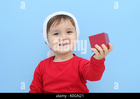 Felice piccolo bambino con una Santa Claus costume apertura di una scatola piccola Foto Stock