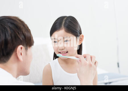 Ritratto di ragazza sorridente e suo padre la spazzolatura dei denti Foto Stock