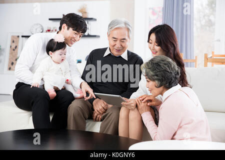 Armoniosa famiglia grande condivisione di un tablet Foto Stock