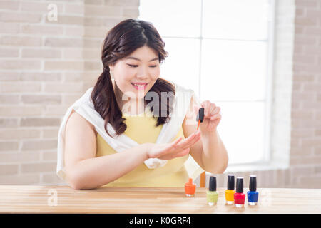 Ritratto di giovane sorridente grasso donna indossa smalto per unghie Foto Stock