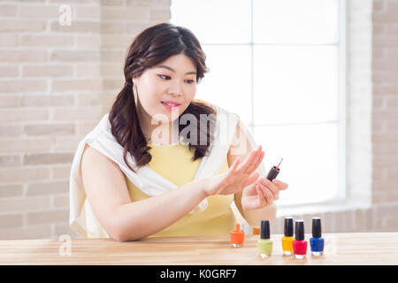 Ritratto di giovane sorridente grasso donna indossa smalto per unghie Foto Stock