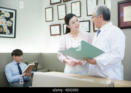 Donna sorridente e dentista parlando a dental clinic Foto Stock