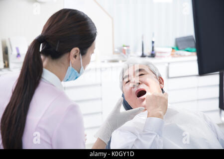 Igienista dentale di indurimento senior di un paziente di sesso maschile Foto Stock