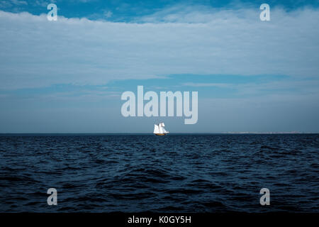 Drammatica seascape con piccoli yacht bianco lontano. Dark acqua di mare Foto Stock