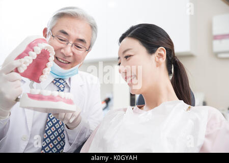 Ritratto di sorridere senior dentista maschio e femmina sorridente paziente Foto Stock