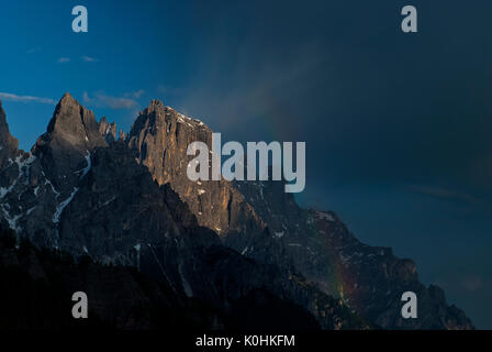 Passo Rolle, Dolomiti, Trentino, Italy. Rainbow nella Pala montagne con le vette della Cima di sfera e il Sass Maor Foto Stock