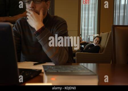 Uno studente universitario prende una pausa dallo studio con un pisolino mentre i suoi coetanei studiano nella Sala di lettura dei Commons di apprendimento di Brody, uno spazio di studio e una biblioteca nel campus di Homewood della Johns Hopkins University a Baltimora, Maryland, 2015. Cortesia Eric Chen. Foto Stock