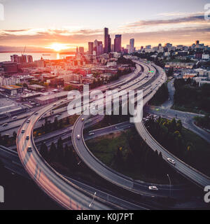 Incredibile tramonto dorato sulla Pacific Northwest città costiera dove la Interstate 5 e 90 le superstrade si intersecano con edifici grattacielo nel centro città skylin Foto Stock