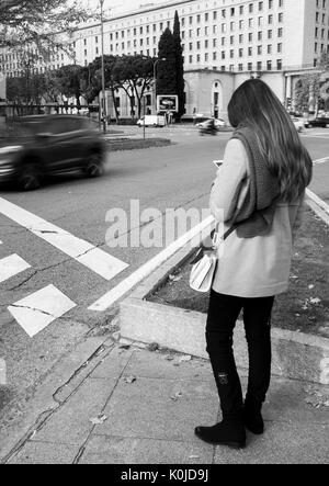 Chica esperando el semáforo para cruzar en la Plaza San Juan de la Cruz. Madrid capitale. España Foto Stock