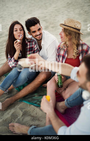 Il gruppo di allegro amici avente un grande momento in spiaggia Foto Stock