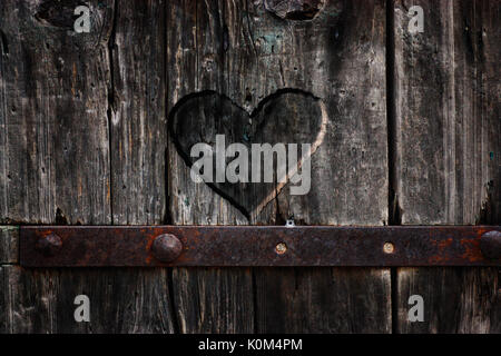 Cuore scolpita in legno. Cuore scuro. Il giorno di San Valentino sfondo Foto Stock