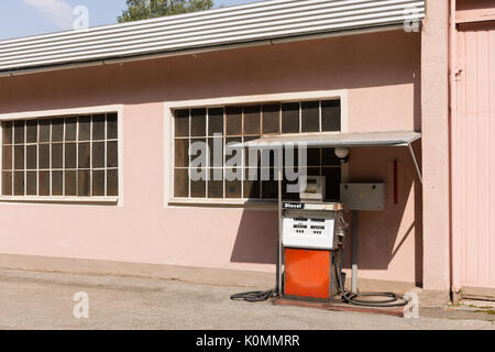 Vecchio diesel pompa benzina in Austria. Stazione di riempimento nella parte anteriore del colore rosa house. Avvertenze in tedesco per la sicurezza del rifornimento: arrestare il motore, senza aprire il fuoco. Foto Stock