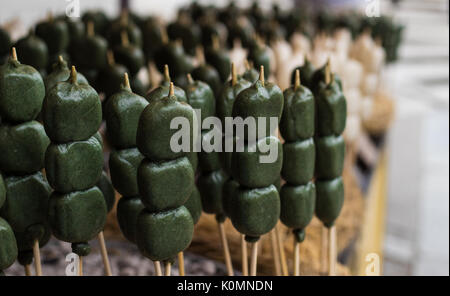 Cucina di strada in vendita al di fuori di un tempio di Kyoto, Giappone - matcha tea gusto lollies su bastoni Foto Stock