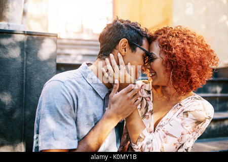 Close up della giovane coppia romantica seduta intimamente vicino a passi di toccare la loro fronte. Felice giovane uomo e donna in atmosfera romantica che esprimono lo Foto Stock